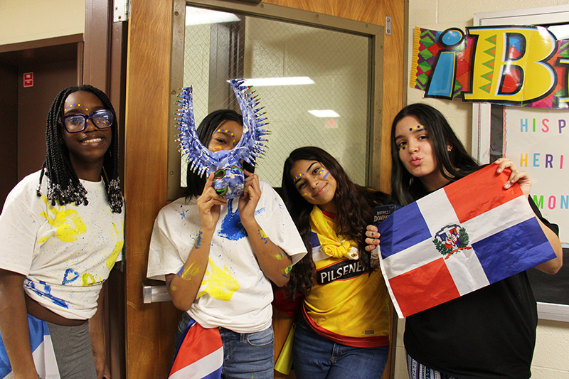 Four high school students holding flags of different countries.