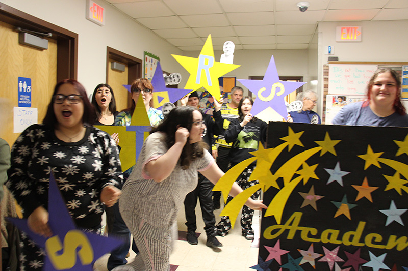 A group of high school kids holding posters that say STARS Academy.