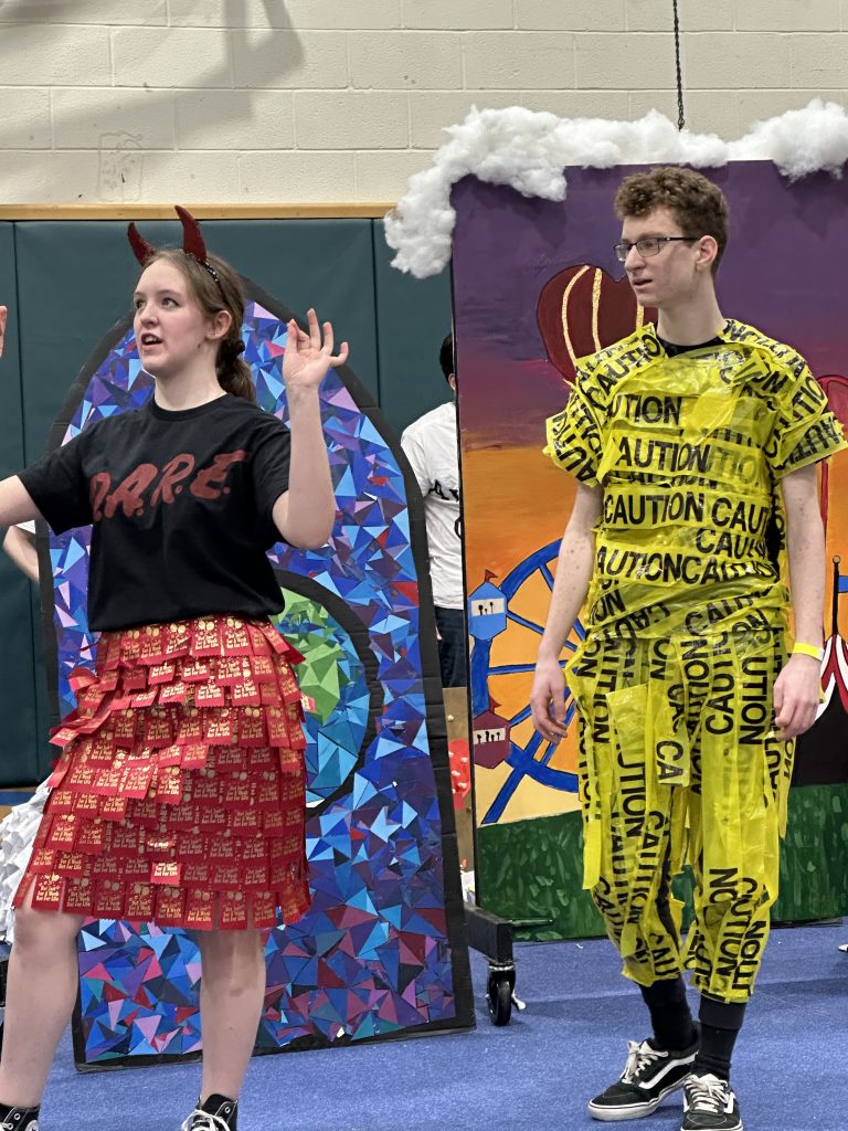 TWo high school kids are wearing funky costumes 