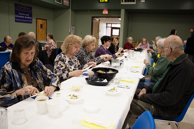 A long table with about eight senior citizens sitting around it.