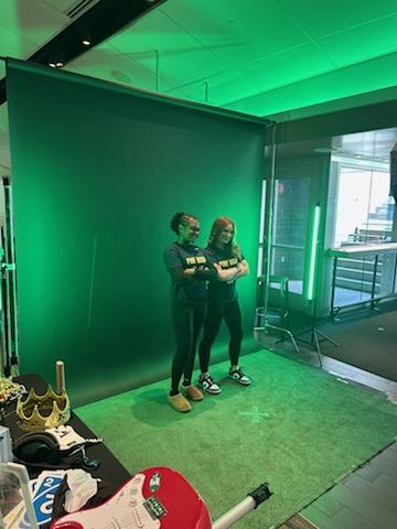 Two high school girls in front of a green screen.