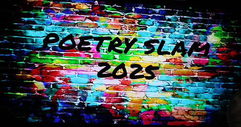 With a multi-colored brick background, this electronic sign says Poetry Slam 2025.