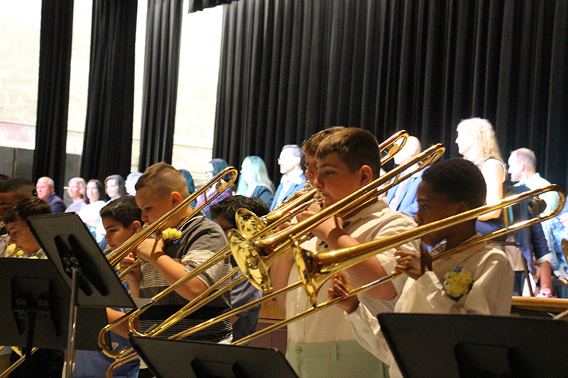 A line of fifth-graders play horns.
