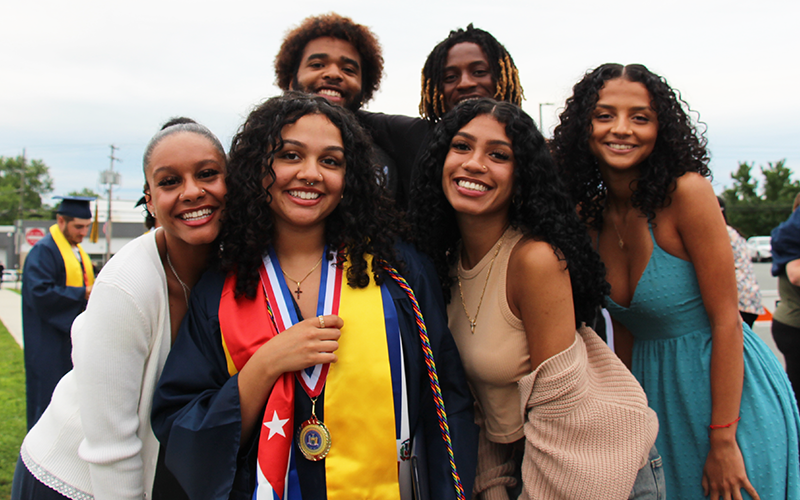 A group of six young people. One is wearing a cap and gown.
