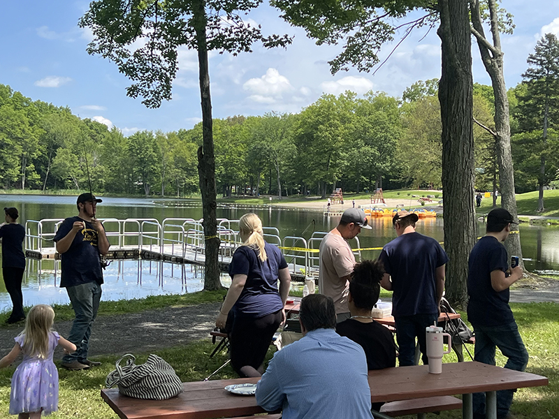 A group of high school kids hold fishing poles and get ready to fish.