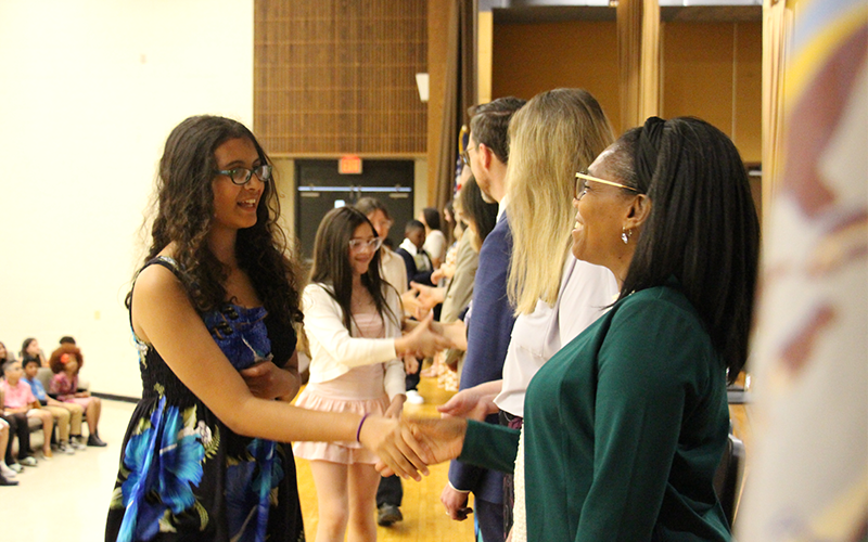 Five students put their handprint signatures on No Place For Hate bulletin board