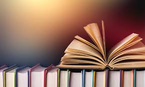 Books lined up one next to the other, with one opened on top of them.