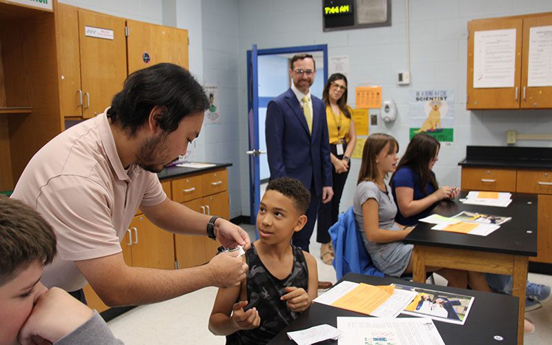 A middle school student serves breakfast to a veteran at Circleville Middle School