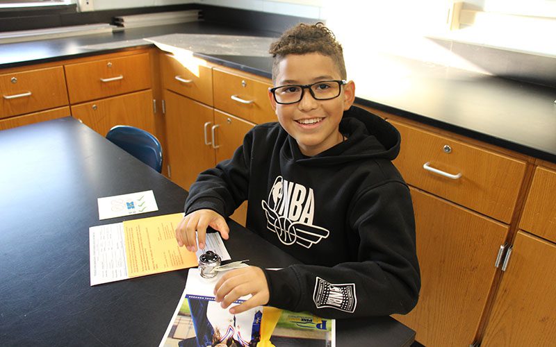 Circleville Middle School student opening his locker and smiling