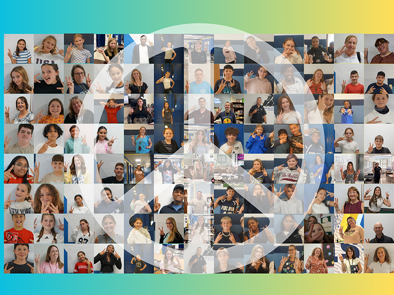 104 small pictures of students and staff members giving the peace sign. In the center is a large white peace sign.