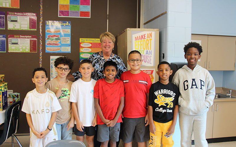 Three girls smiling as they arrive at Pakanasink Elementary School