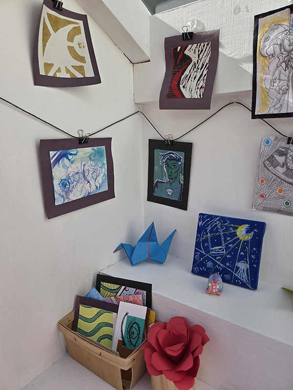 A close up shot of miniature artwork hanging in the white box.