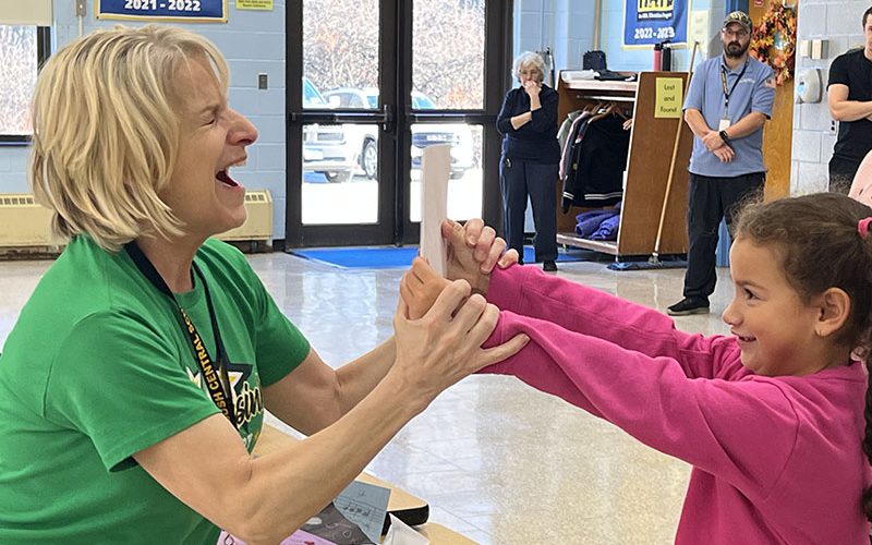 Three girls smiling as they arrive at Pakanasink Elementary School