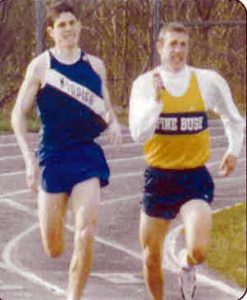Two high school boys running track.