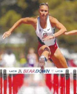 A young woman jumps hurdles.