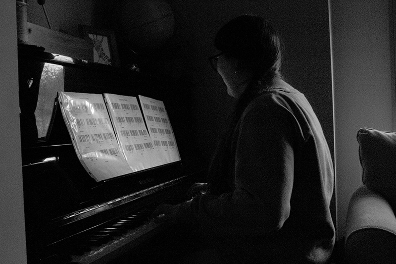 A black and white drawing of a person playing a piano.