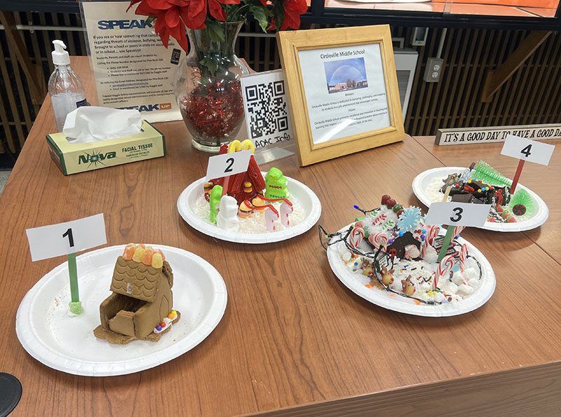 Four gingerbread houses on plates.