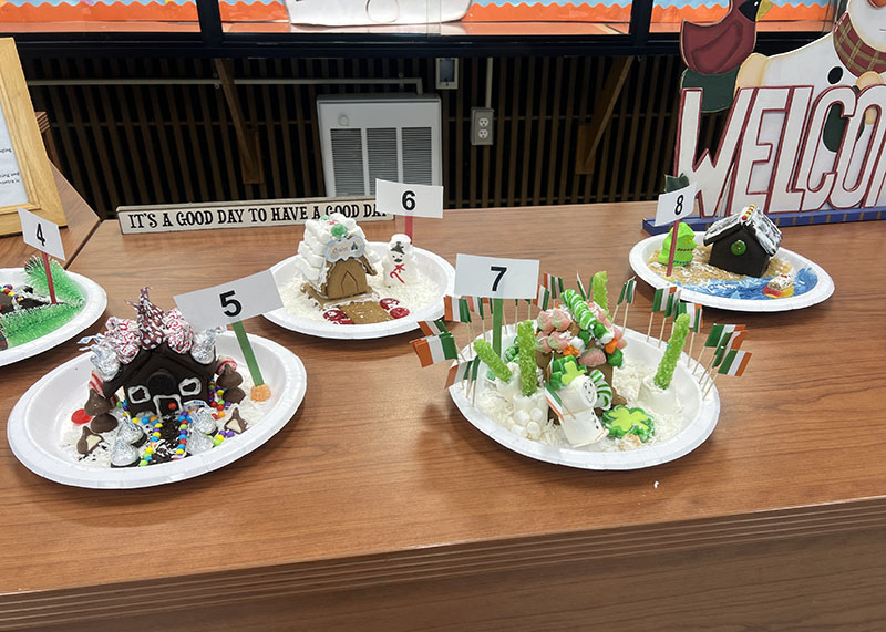 Four gingerbread houses on plates.
