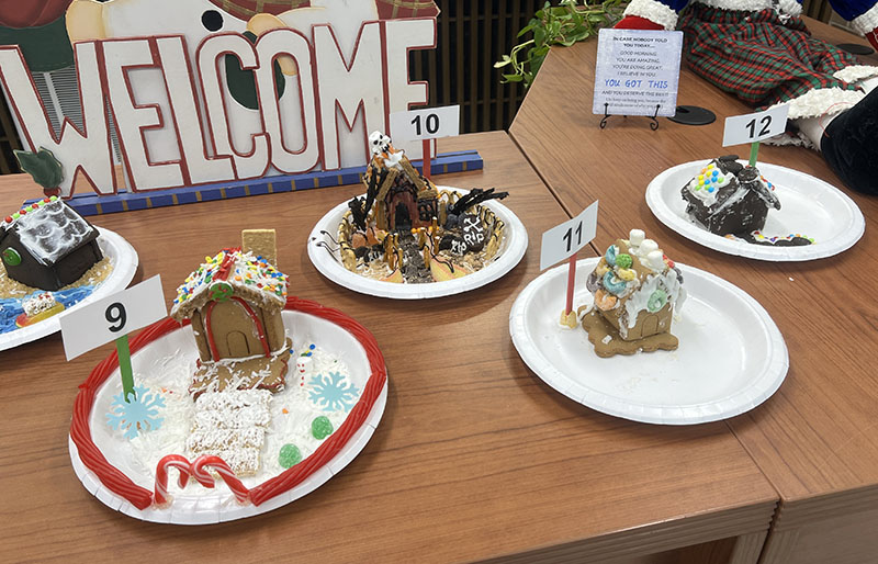 Four gingerbread houses on plates.