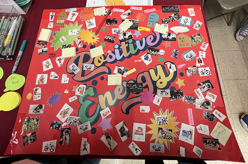 A red background on this large bulletin board. It says Positive Energy. There are small pieces of paper with positive messages.