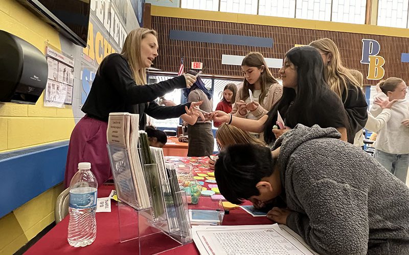 A middle school student serves breakfast to a veteran at Circleville Middle School