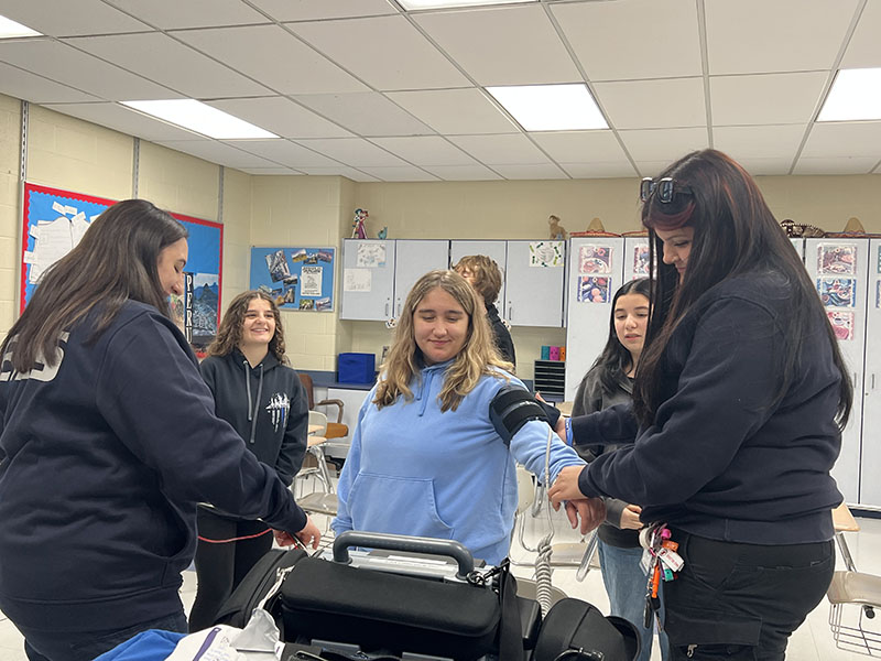 An EMT takes the blood pressure of a middle school girls.