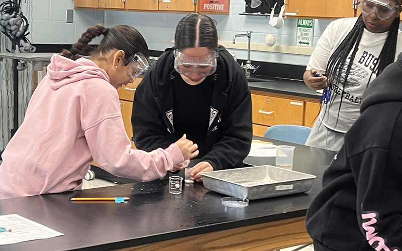 middle school students work together on a science experiment.