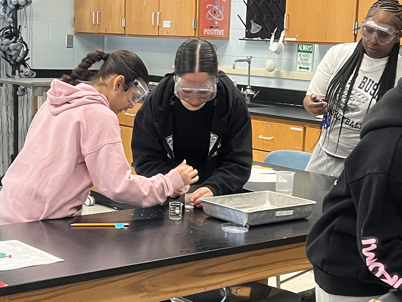 middle school students work together on a science experiment.