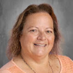 A woman with shoulder-length blonde hair smiles. 