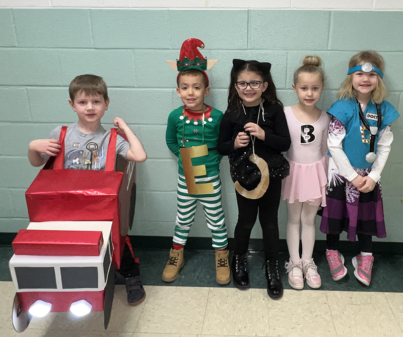 Five kindergarten kids stand together in costumes.