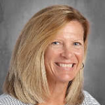 A woman with shoulder-length blonde hair smiles.