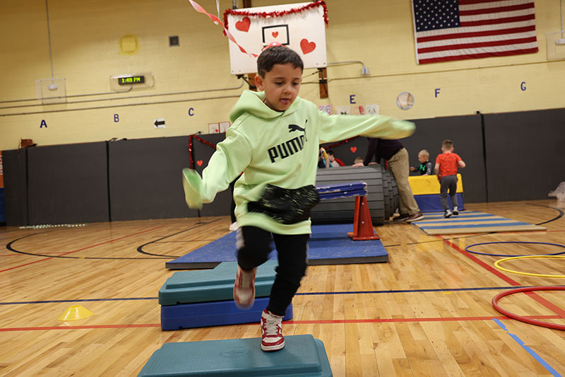 A kid runs an obstacle course.