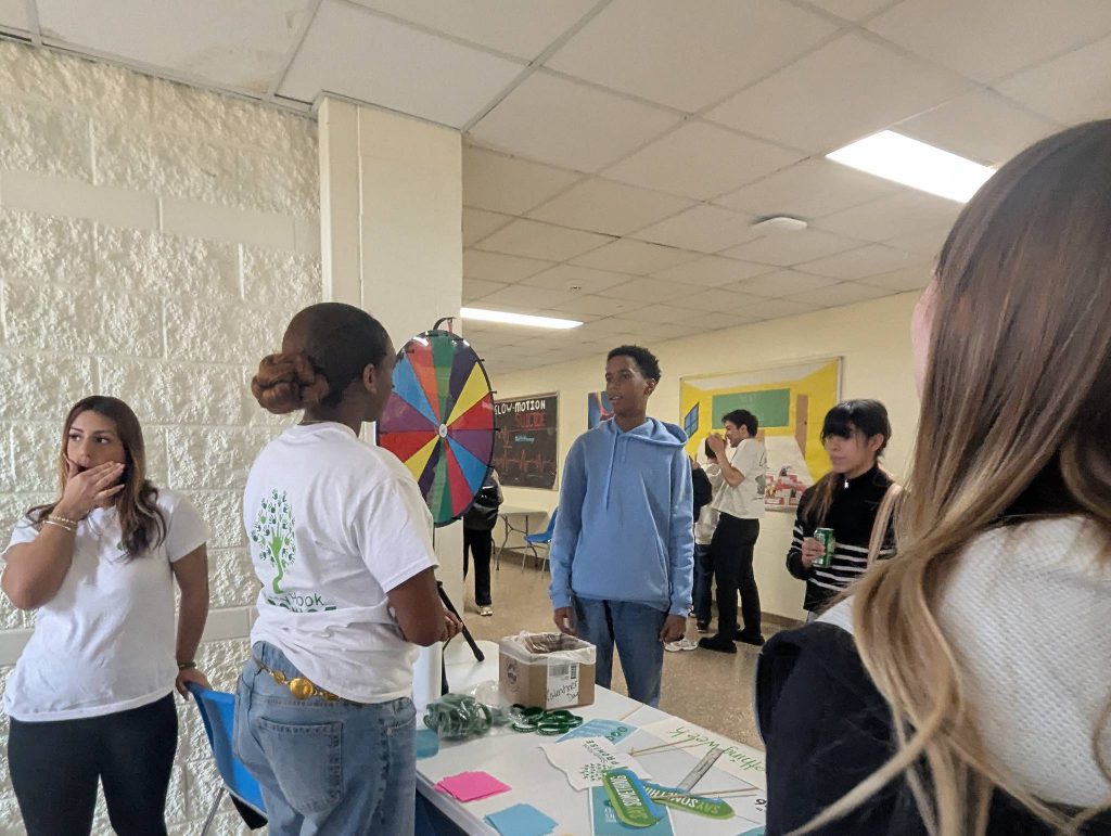 High school kids gather at a booth where information is being handed out.