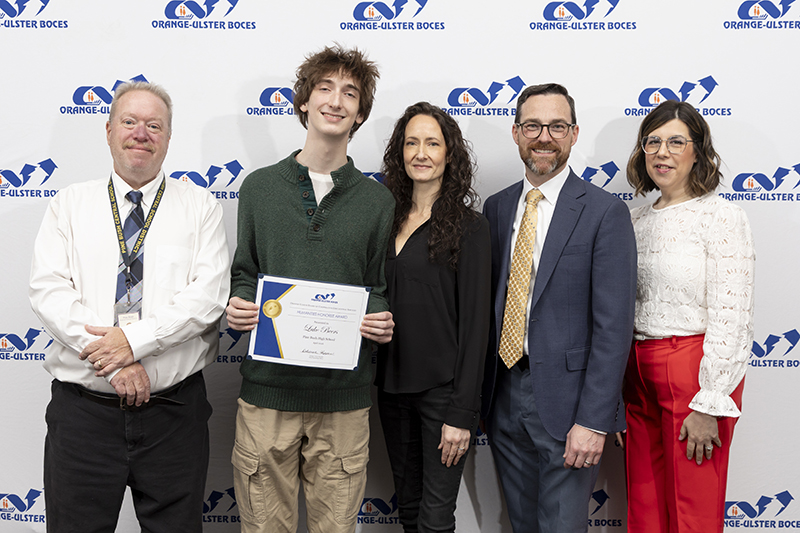Five people stand together smiling. They are in front of a background that says OU BOCES. The high school kid in the center holds a certificate.