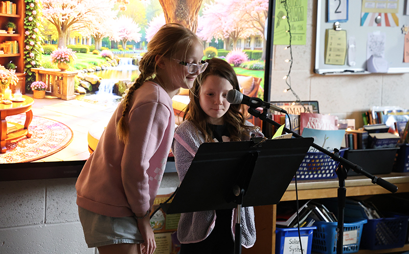 Two fourth-grade girls read their poetry.