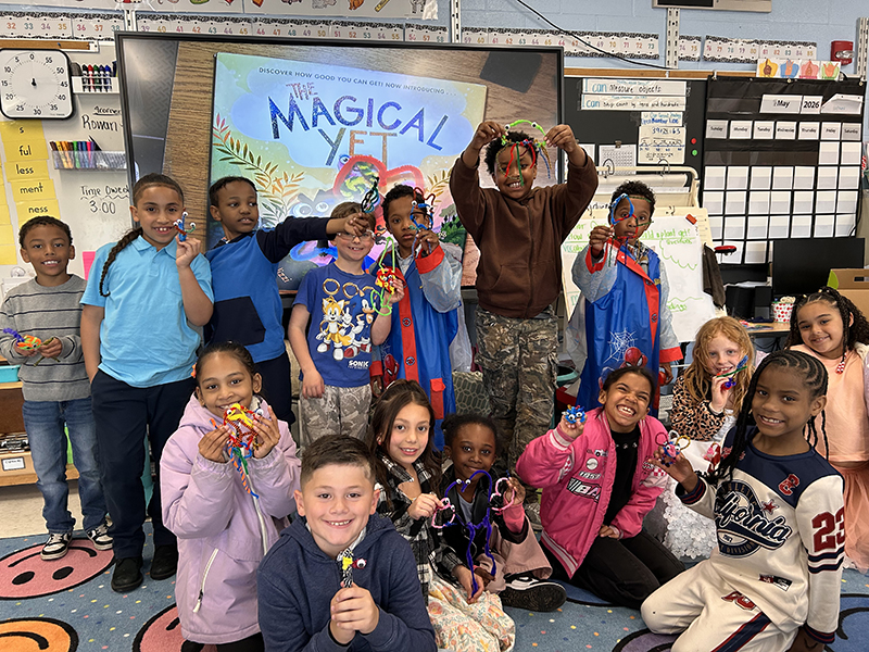 A group of 15 second graders all smiling and holding their little yet pets.