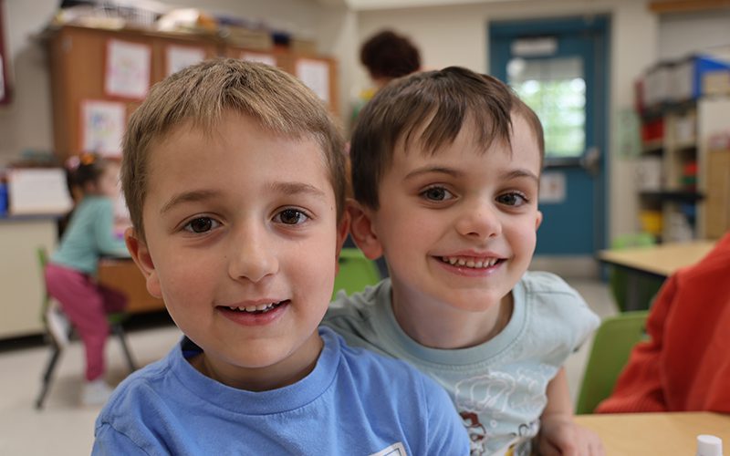Two kindergarten boys smile.