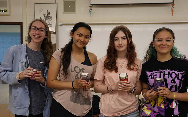 PBHS Wellness club group Four high school kids hold little jars of scented oils they made.