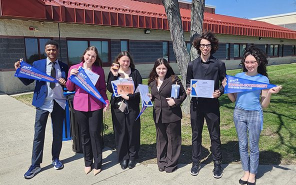 PBHS Youth in government group Six high school students stand outside of a large building. Each holds a certificate or pennant.