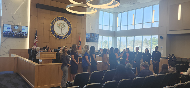 A group of high school students stand in a court chamber.