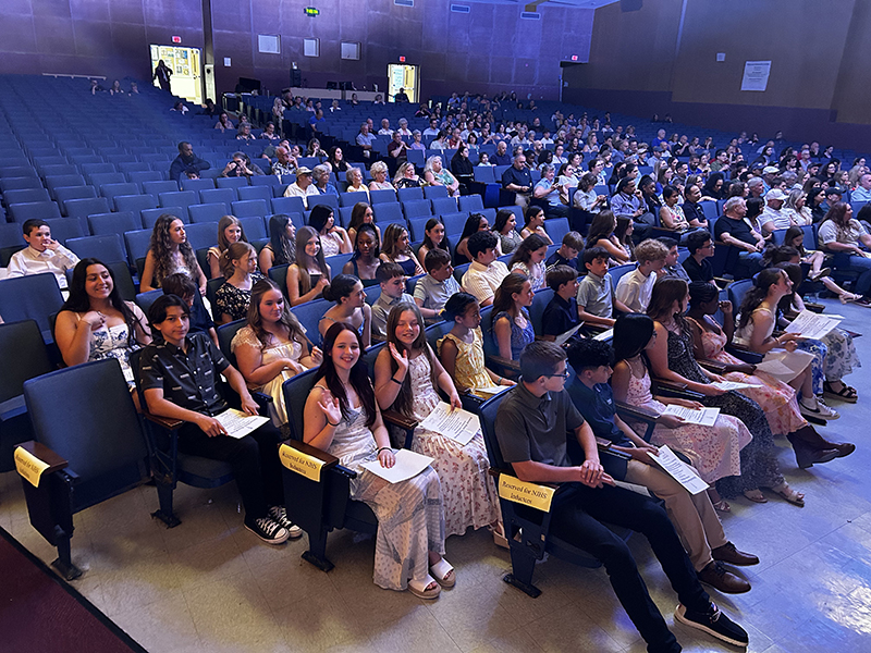 A large number of people sitting in an auditorium.
