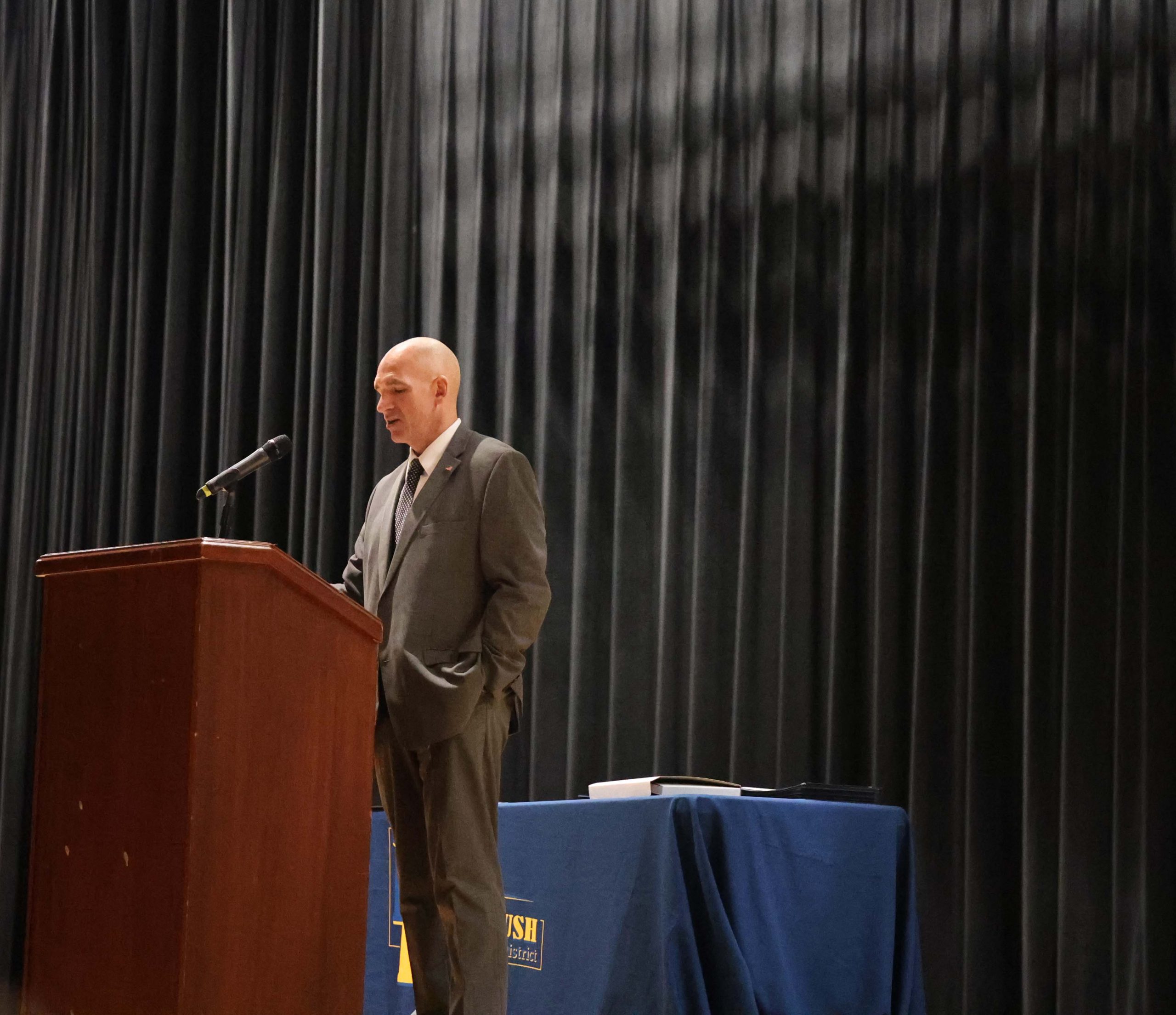 A man stands at a podium speaking on a stage.