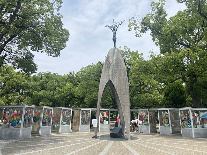 A large concrete structure with a statue of children with their arms outstretched on top.