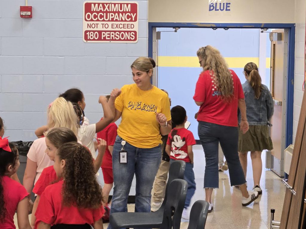 principal giving fist bumps to kids leaving the cafeteria