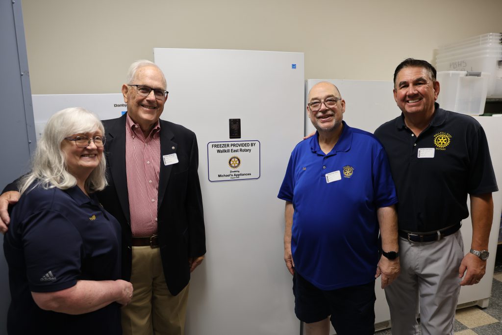 group of people standing in front of a freezer