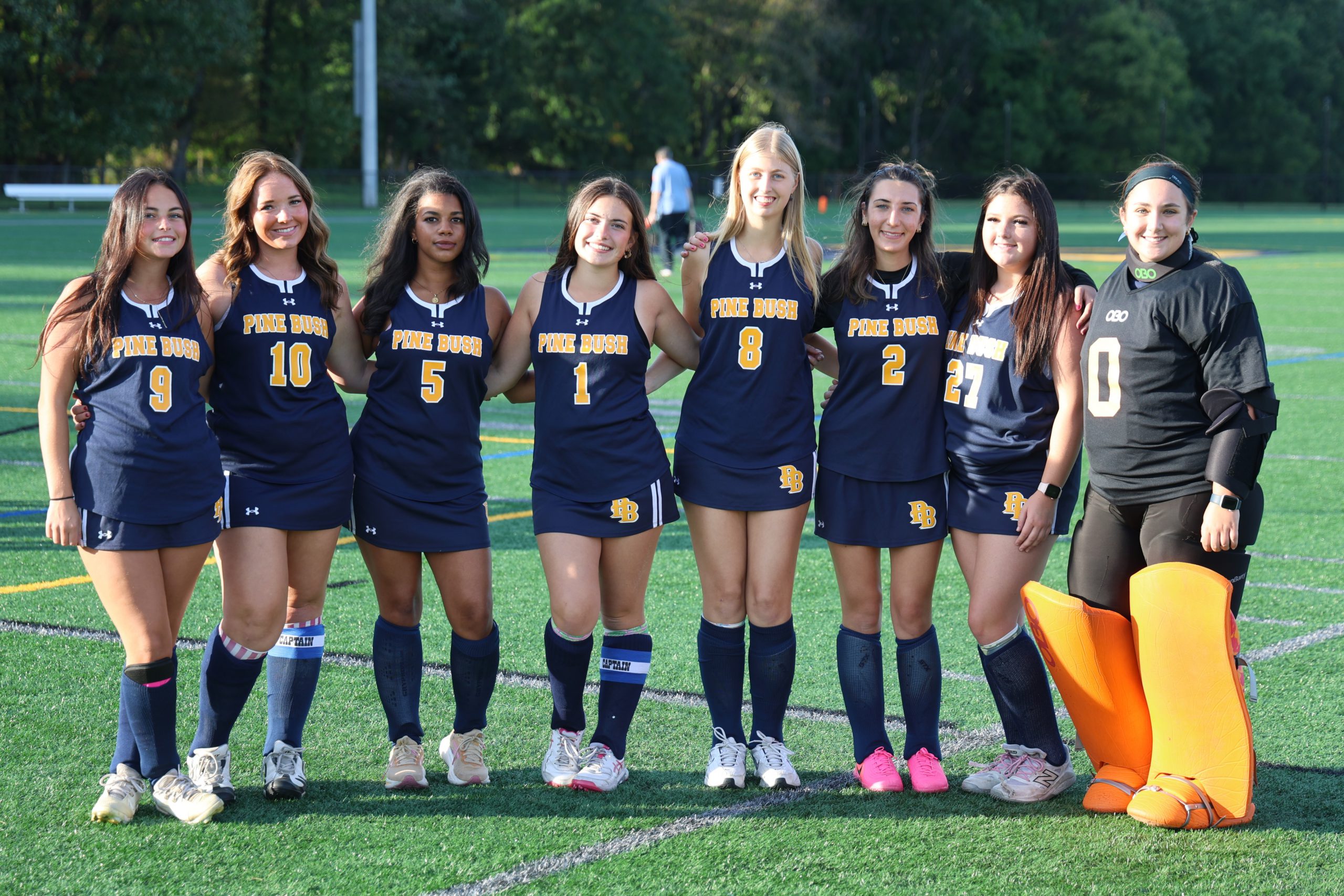 group of women in field hockey uniforms standing for picture