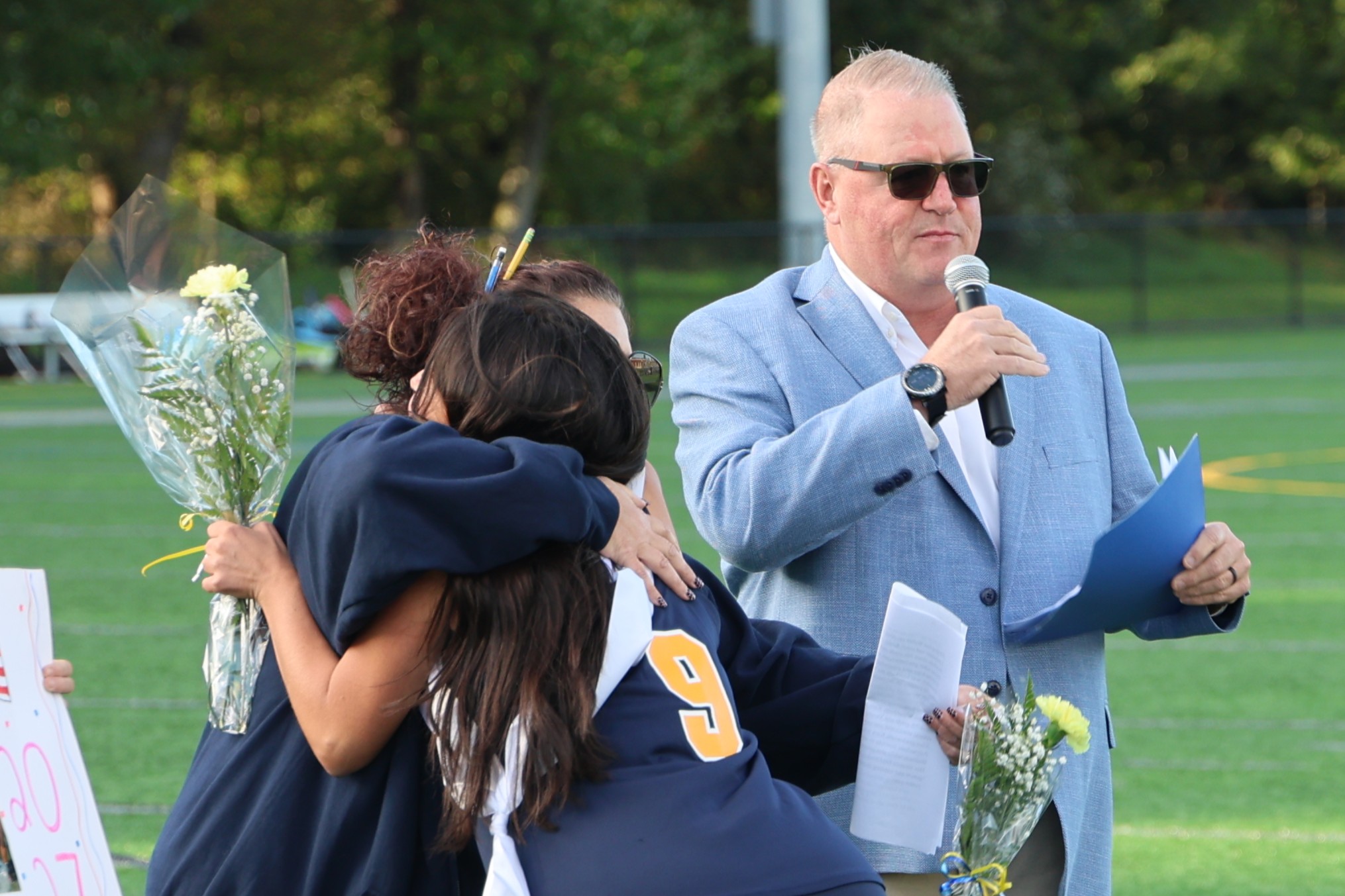 field hockey player hugging their coach