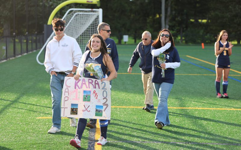 3J9A7279 girl walking down a sports field with her family