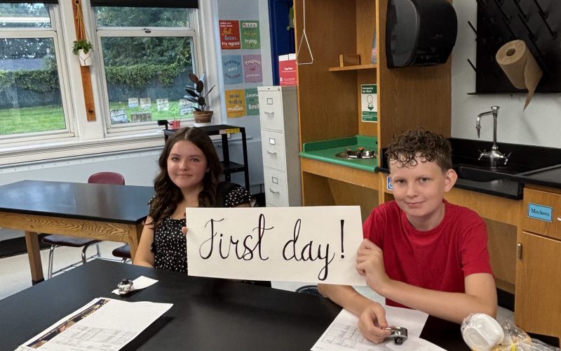 kids holding up a sign that says first day