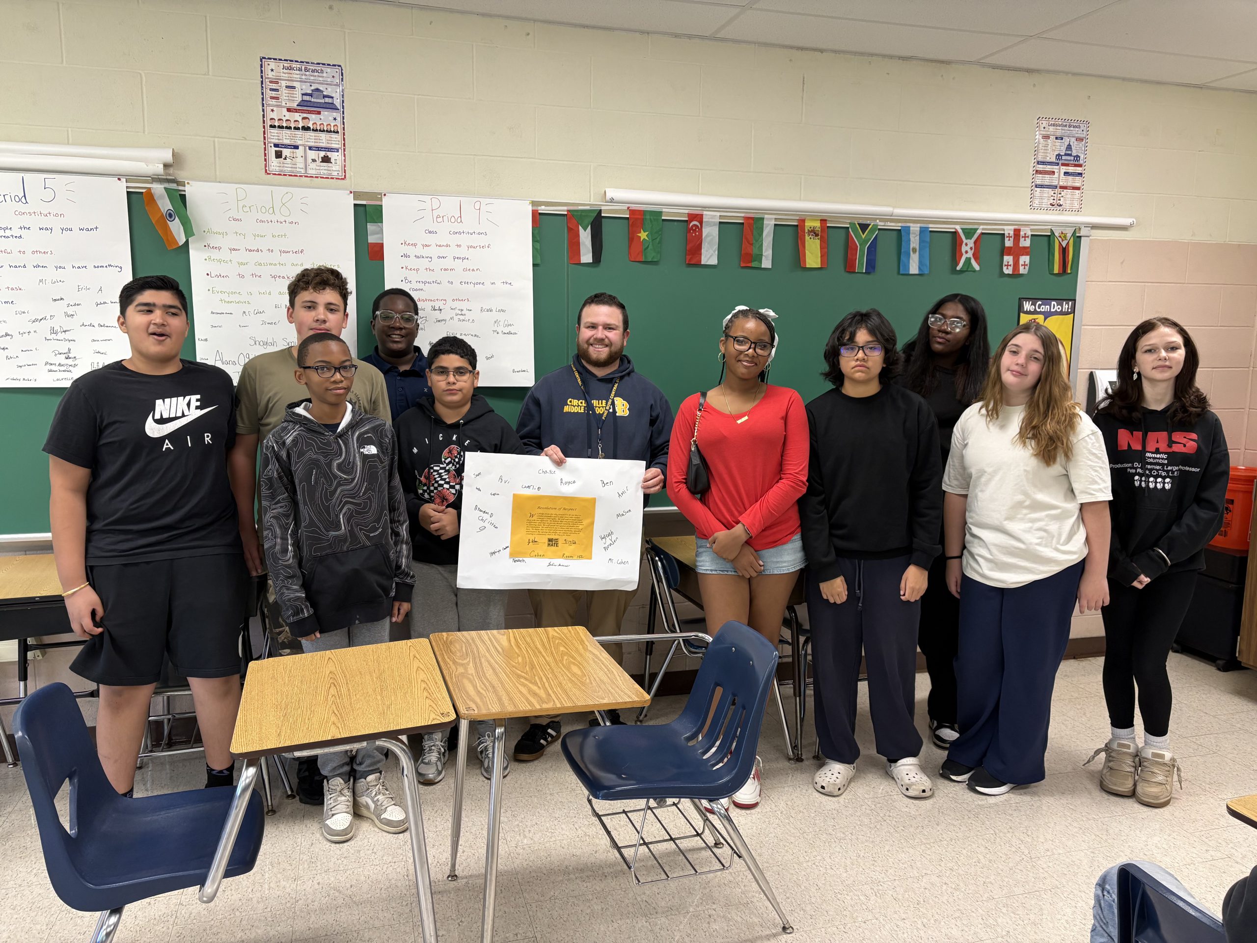 students gathered together for picture while holding poster